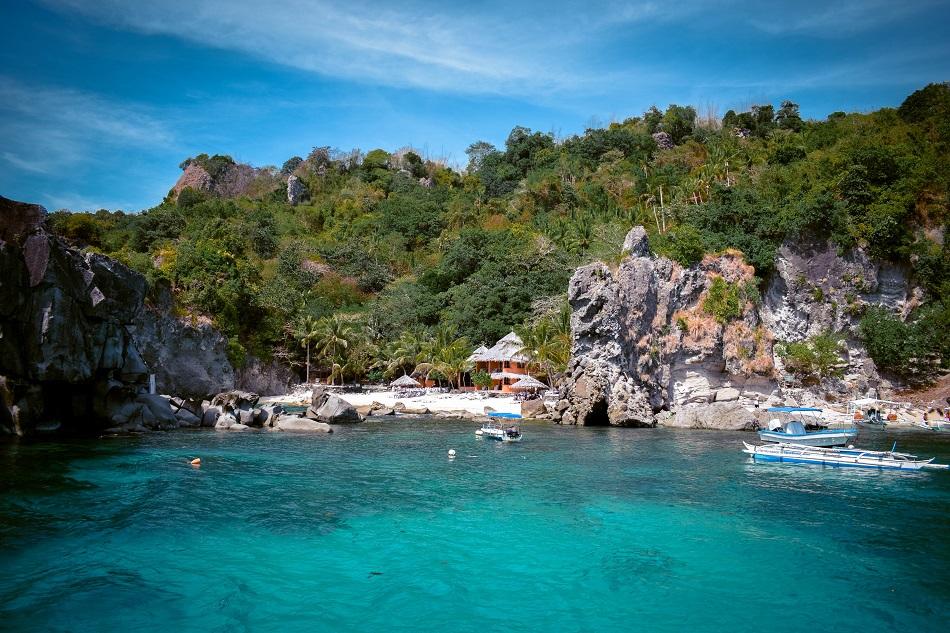 Beach with palm trees and stones at Apo Island, Philippines