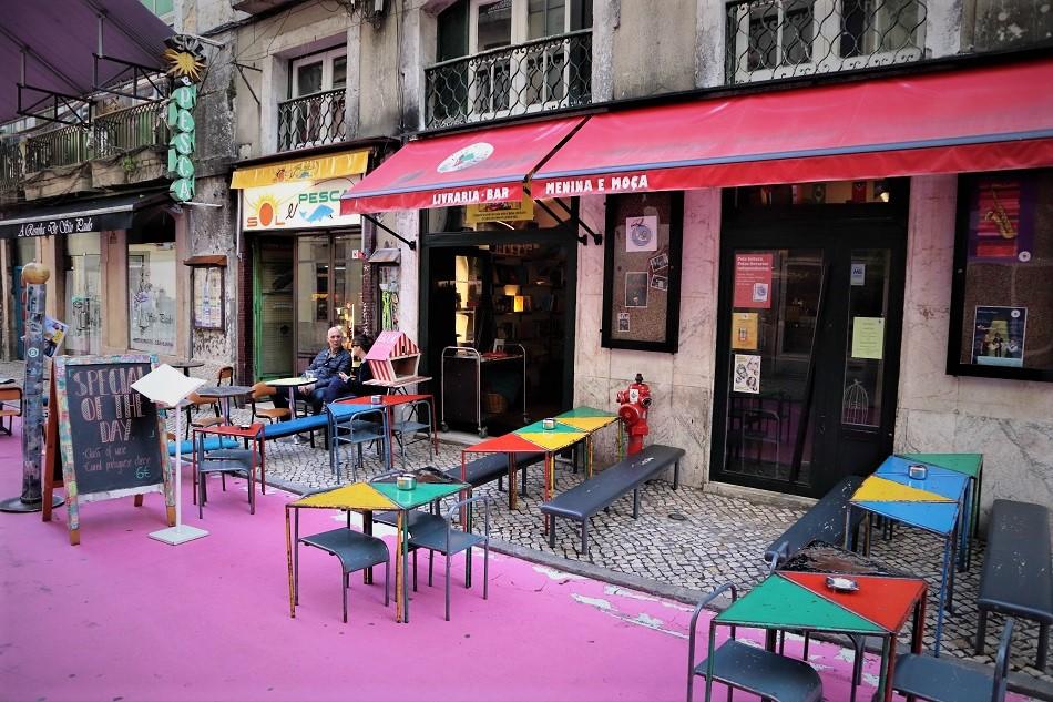 Pink street Lisbon restaurants with tables and chairs outside