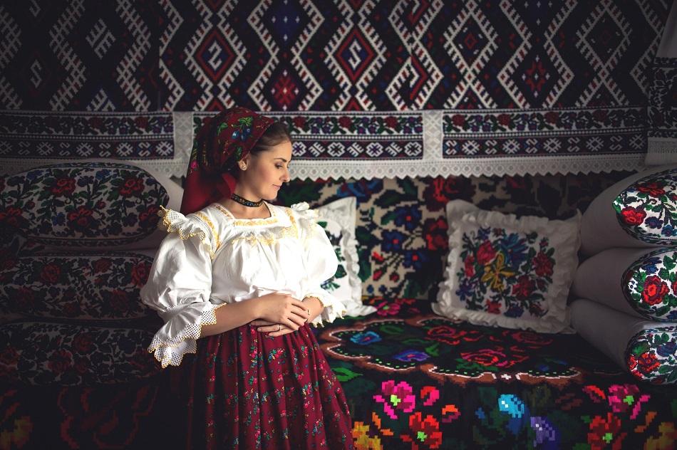 Girl dressed in traditional Romanian clothes in a traditional house