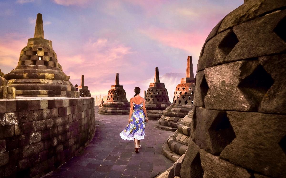 Aurelia Teslaru walking between round stupas at Borobudur Temple Yogyakarta, Java Island. Biggest Buddhist temple in the world